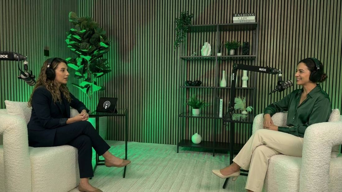 Two women recording a podcast in green lighting